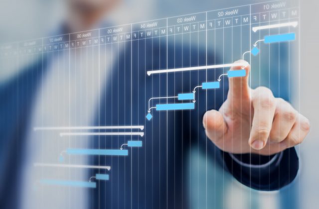 Project manager updating tasks and milestones progress planning with Gantt chart scheduling interface on a virtual screen